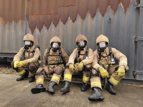 Four firefighters take a break during their breathing apparatus training