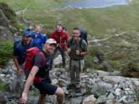 A group of happy hikers smile at the camera in Ogwen Valley, Snowdonia
